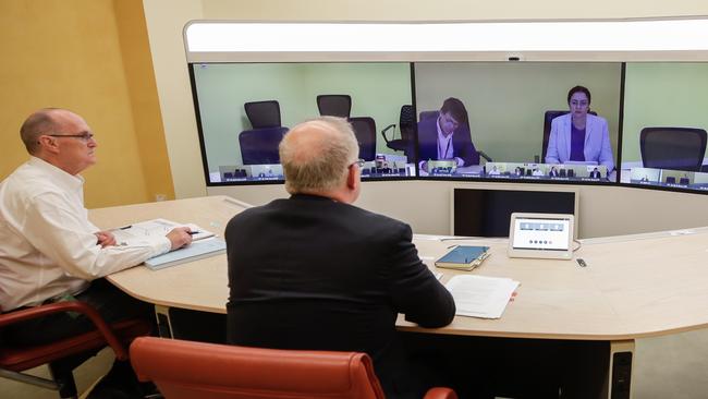 Secretary of the Department of Prime Minister and Cabinet, Phil Gaetjens, and Scott Morrison speak with Queensland Premier Annastacia Palaszczuk, on screen, during a national cabinet meeting to discuss COVID-19. Picture: Getty Images