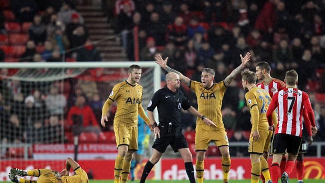 Tottenham players surround Lee Mason.