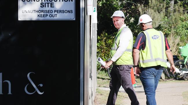 Builders collecting tools and equipment, being watched by security, and leaving the Midwater building site at Main Beach. Picture Glenn Hampson