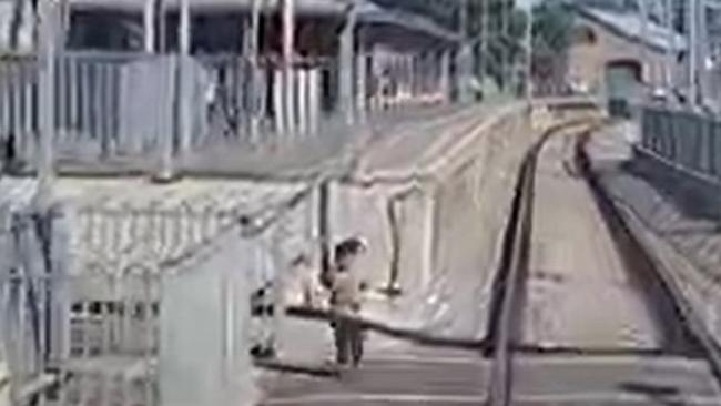 A child runs through a safety barrier and stops just centimetres from where a train was travelling past. Picture: Supplied