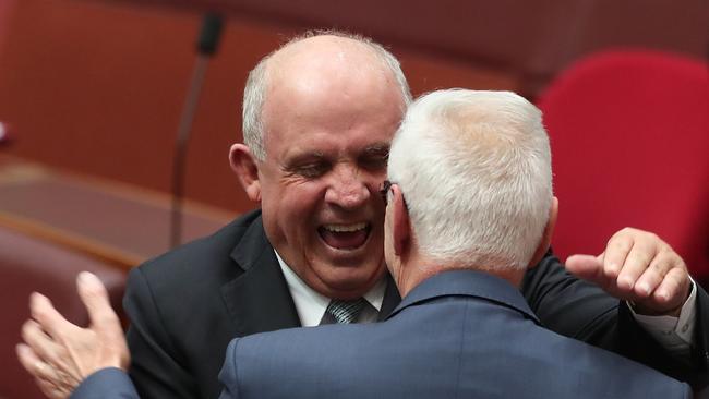 Senator Williams is congratulated by Senator Doug Cameron in the Senate Chamber. Picture: Kym Smith