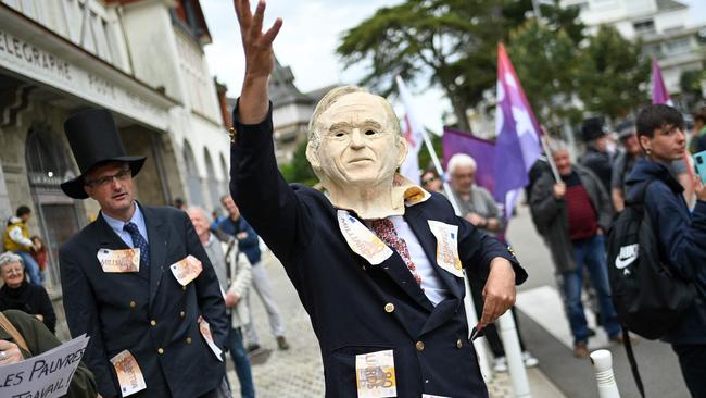 A protester wearing a mask of French businessman Bernard Arnault gestures during a demonstration called by unions trade parodying the wealthy class. Picture: Sebastien Salom-Gomis/AFP