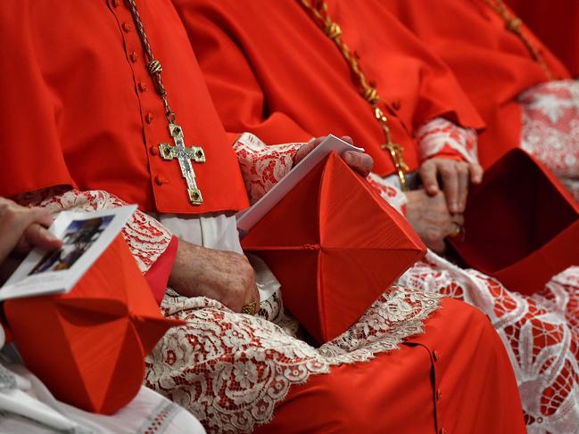 (FILES) Cardinals hold their berretta square cap (Biretta) on their knee as they attend a Pope's Ordinary Public Consistory for the creation of new cardinals, for the imposition of the biretta, the consignment of the ring and the assignment of the Title or Diaconate, on October 5, 2019 at St. Peter's Basilica in the Vatican. The death of Pope Francis on April 21, 2025 sets in motion centuries-old traditions which will culminate in the election by cardinals of a new pontiff. Under a system originating in the 13th century, the conclave sees cardinals aged under 80 meet in private to choose the next pope from among their peers. They are sworn to absolute secrecy, under pain of ex-communication, during the voting. (Photo by Tiziana FABI / AFP)