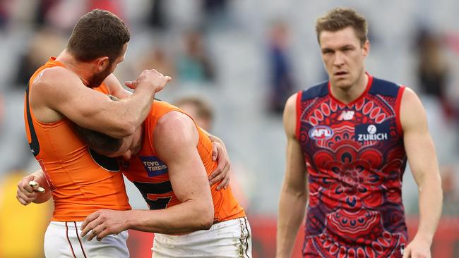 Giants Sam Reid and Jacob Hopper celebrate as Demon Tom McDonald laments his side’s loss. Picture: Getty Images