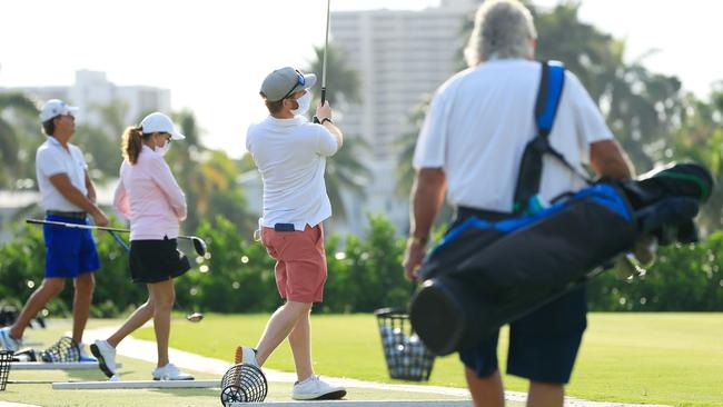 Players wearing face masks warm up on a driving range at the Miami Beach Golf Club on April 29. Picture: AFP