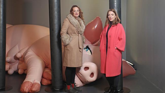 Dark Mofo executive producer Lucy Forge, left, and Dark Mofo associate creative director Hannah Fox with the giant inflatable mother pig at Saeborg’s exhibition at the old Avalon Theatre. Picture: LUKE BOWDEN