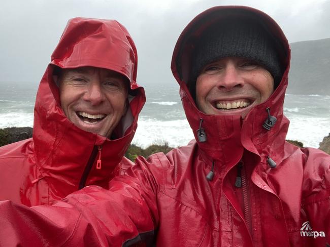 Phil Young takes a selfie with Life's an Adventure Three Capes Walk guide Craig Fardell on a wild day at Maingon Bay Lookout. Picture: Philip Young