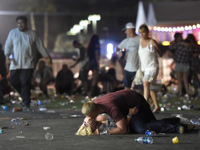 A man comforts an injured woman at the scene of the shooting. Picture: Getty Images