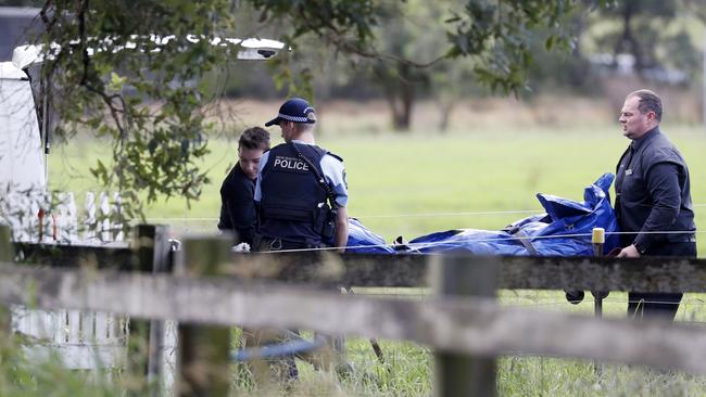 The body of a man is removed after he was trapped in a vehicle submerged in flood water on Cut Hill Rd at Cobbitty. Picture: Jonathan Ng