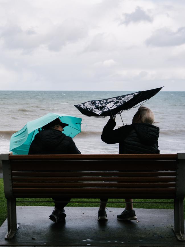 Two women are seen with umbrellas on Glenelg Esplanade on Thursday. Picture: AAP Image/ Morgan Sette