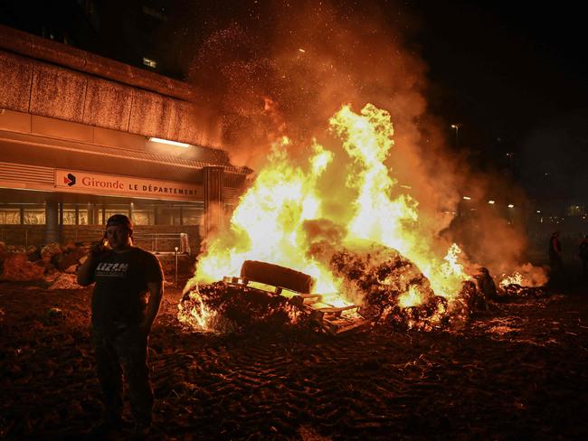 Farmers protest in Bordeaux, France, surrounded by burning hay-bales, demanding government action against high costs and strict environmental rules. Picture: Philippe Lopez/AFP