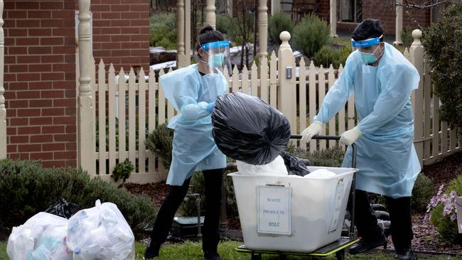 Staff in PPE remove waste at Japara Goonawarra Aged Care Home in Sunbury. The facility was one of many hit with a COVID-19 outbreak. Picture: David Geraghty