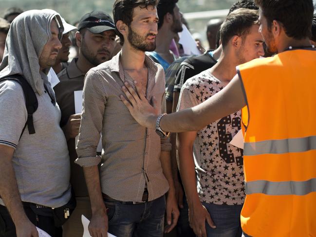 Migrants wait to complete their registration procedure by the police at a new registration center held at a stadium on the Greek island of Lesbos on September 8, 2015. The Greek island of Lesbos is "on the verge of explosion" with violence erupting as the more than 15,000 mainly Syrian refugees push local resources to the limit, the immigration minister said on September 7. Yiannis Mouzalas told To Vima radio that boats taking refugees to the Greek mainland would soon be using a second port to ease pressure on the island of 85,000 inhabitants. AFP PHOTO / ANGELOS TZORTZINIS