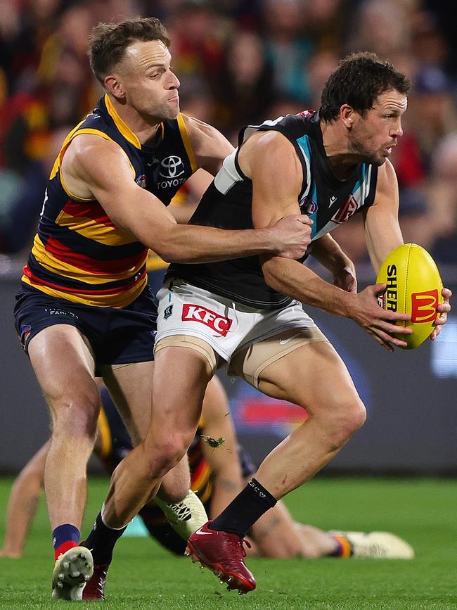 Crow Brodie Smith (left) tackles Port Adelaide’s Travis Boak after coming on as a sub in Showdown 55. Picture: Sarah Reed/AFL Photos via Getty Images