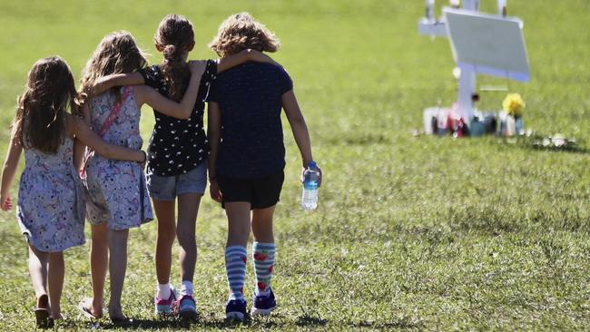 Four young children approach a vigil post at Park Trails Park, a gathering place for the community to honor the 17 students that were killed by a former student at Marjory Stoneman Douglas High School on Valentine’s Day, 2018. Picture: AP