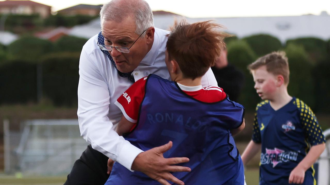 Prime Minister Scott Morrison crashes into Luca Fauvette during under-8s training at Devonport Strikers Soccer Club in Tasmania while on the election campaign trial on May 18. Picture: Getty Images
