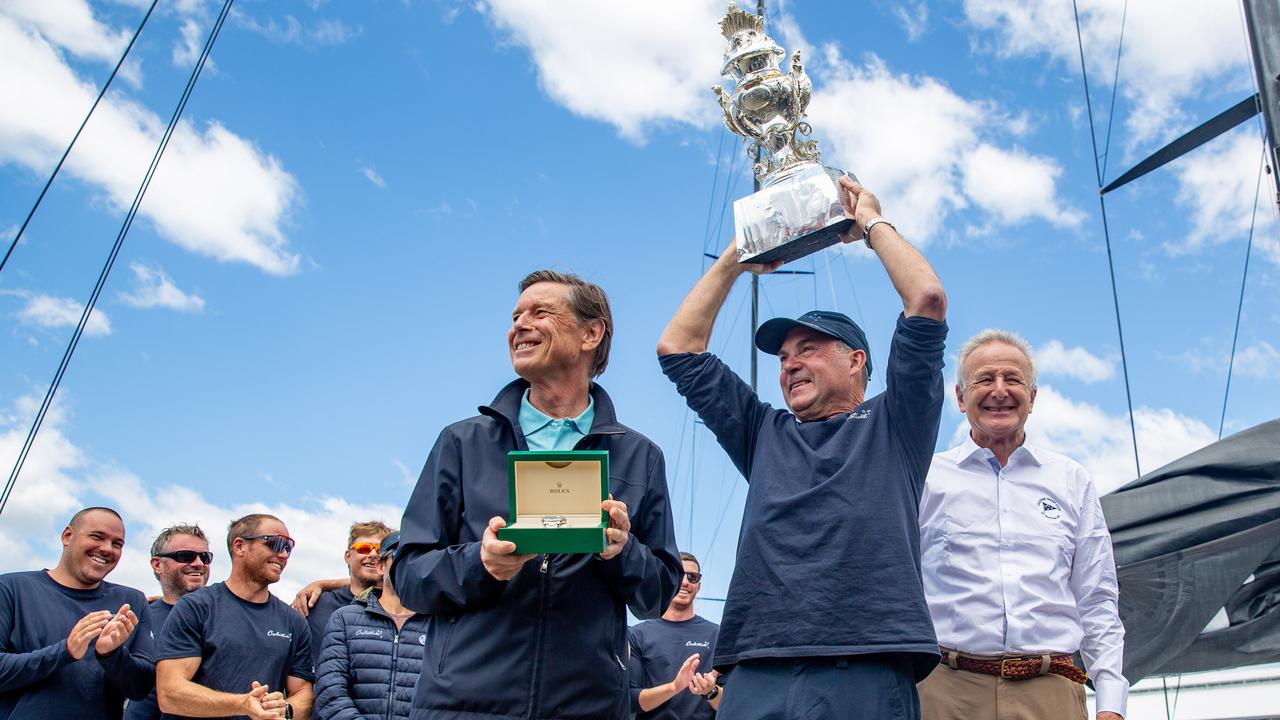 Celestial Skipper Sam Haynes is presented with the Tattersalls cup by vice commodore of the Cruising Yacht club of Australia David Jacobs and a timepiece was presented by Laurent Delaney of Rolex for winning the overall honours for the 2024 Rolex Sydney to Hobart Picture: Linda Higginson