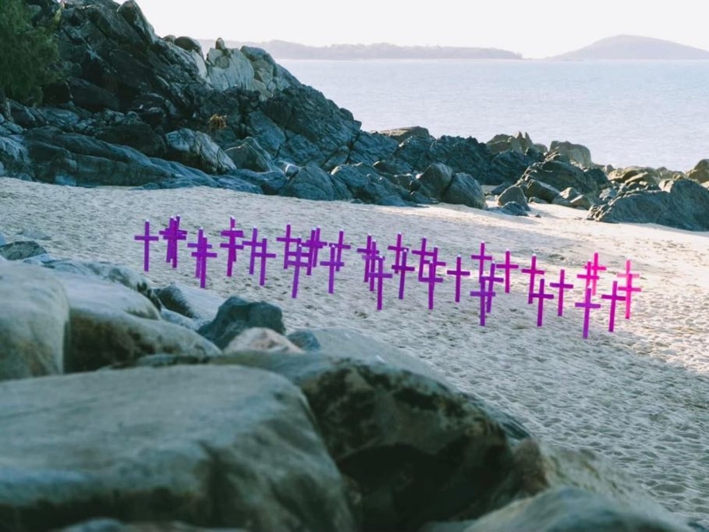 Pink crosses line the sand for the 2024 candlelight ceremony at Mackay Harbour.