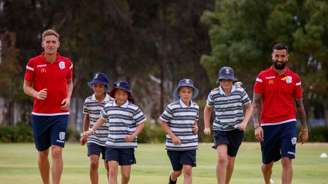 Adelaide United players Kristian Opseth and Paul Izzo with students Luca Fouyaxis 10, Charlotte Zhang 9, Nicholas Belegris, 9, and Claudia Lee, 9, at Immanuel College.