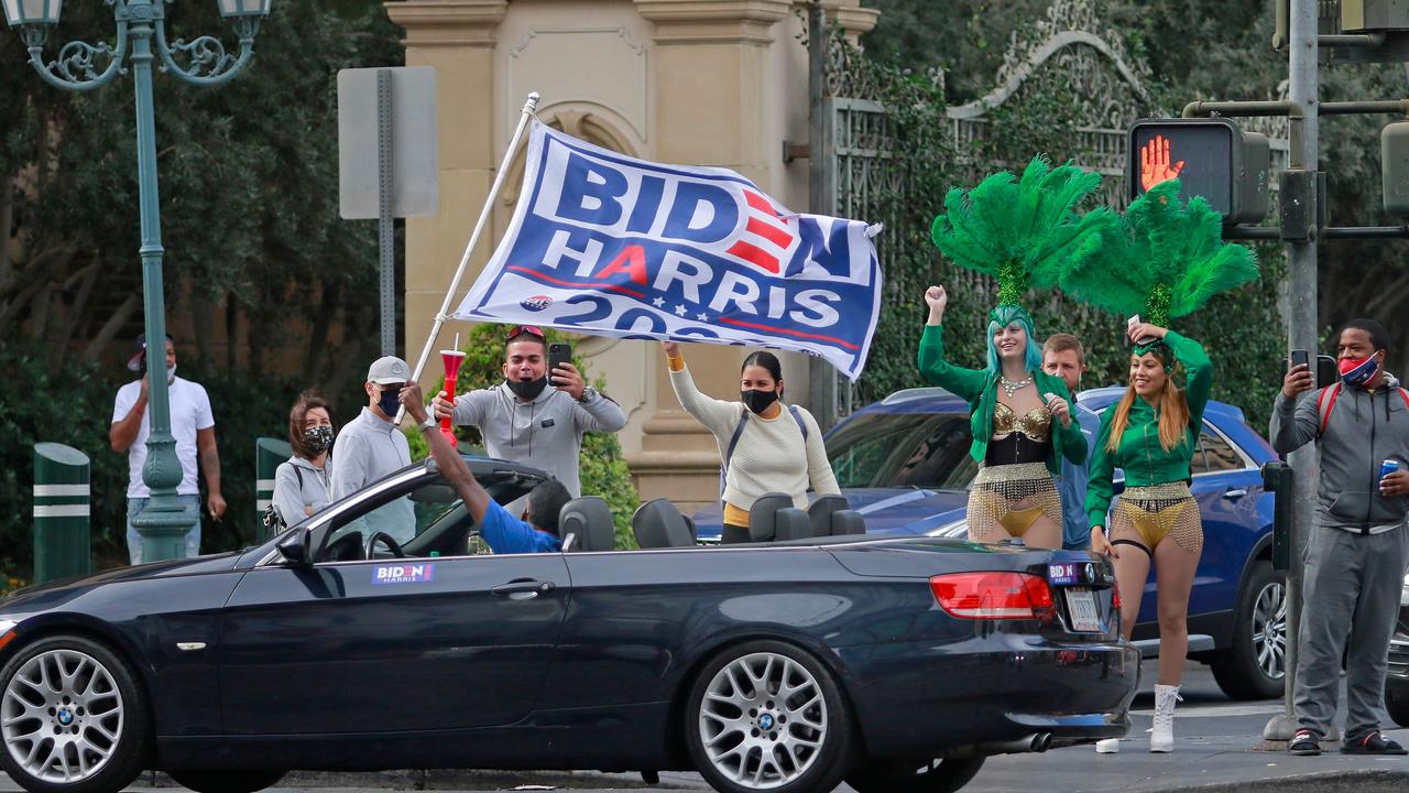 A man waves a Biden-Harris flag while driving along the Las Vegas Strip shortly after Joe Biden was declared the winner of the 2020 presidential election on November 7, 2020, in Las Vegas. Picture: Ronda Churchill / AFP