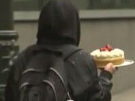 Footage of a woman walking through protesters, unfazed and carrying a cheesecake, has taken the internet by storm. Picture: Supplied