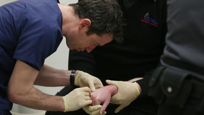 Medical and security staff work together to try to calm an ice patient. Picture: Gary Ramage