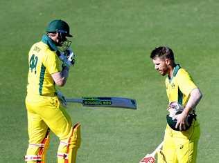 David Warner of Australia walks from the field after being dismissed as Steve Smith is seen walking in to bat at Allan Border Field. Picture: Bradley Kanaris