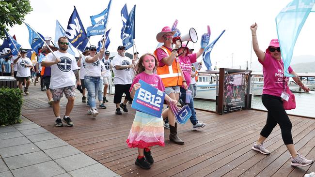 Lilith Ryan, 8, walks with her mother, Suri Hobday, from the Queensland Nurses and Midwives Union in the annual Labour Day march in Cairns City. Picture: Brendan Radke