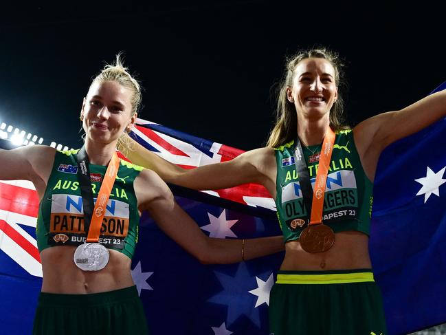 Silver medalist, Australia's Eleanor Patterson (L) and bronze medalist, Australia's Nicola Olyslagers (R) celebrate with their National flags and medals after the women's high jump final during the World Athletics Championships at the National Athletics Centre in Budapest on August 27, 2023. (Photo by Ben Stansall / AFP)