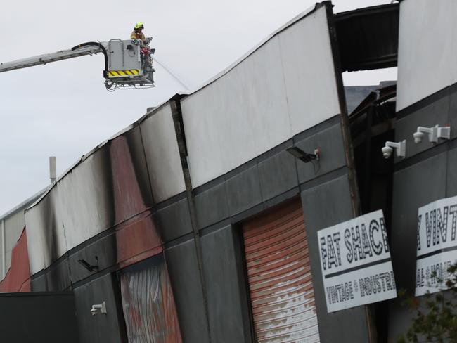 Fire fighters at a factory fire in Age street, Cheltenham where a large wall is in danger of collapsing. Picture: David Crosling