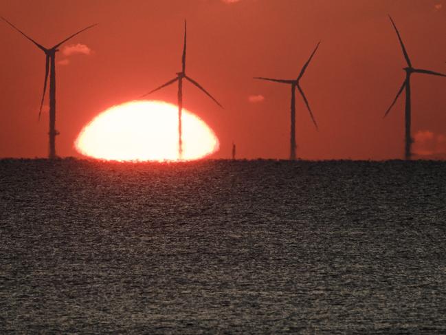 (FILES) In this file photo taken on December 9, 2022, the sun sets over an offshore wind farm, off the coast of the French Western city of Saint-Nazaire. - The European Union Parliament and EU states reached a deal on March 30, 2023 to almost double the share of renewables in the 27-nation bloc's overall energy consumption by 2030. The provisional political agreement seeks to raise the share of renewable energy to 42.5 percent, from 22 percent today, according to a Council of the EU statement, which represents the bloc's governments. (Photo by LOIC VENANCE / AFP)