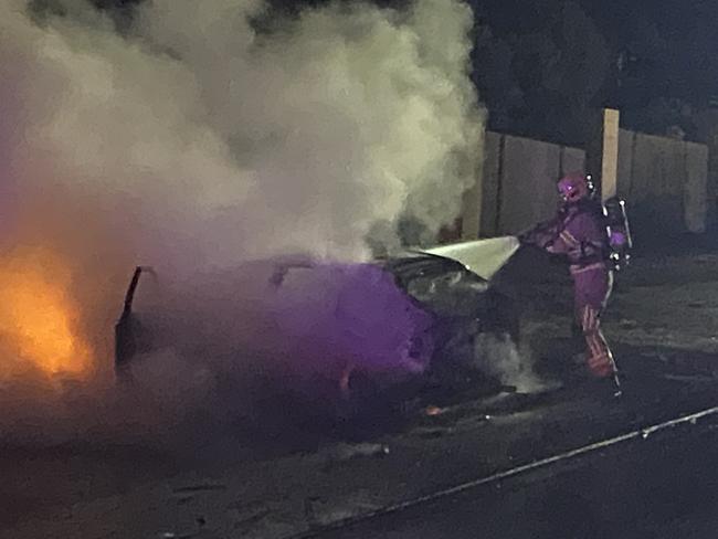 A fireman puts out a car fire in Blackmans Bay. Picture: PHIL YOUNG