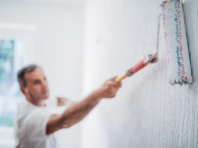 Painter man at work with a paint roller