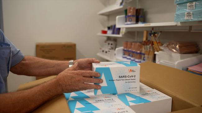 A school official unpacks a box of RATs. Picture: Supplied via NCA NewsWire