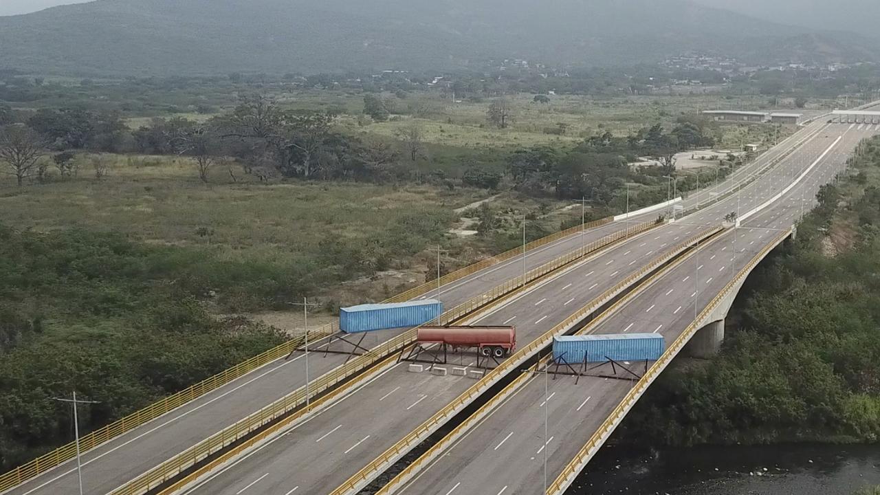 A fuel tanker, cargo trailers and makeshift fencing block the Tienditas International Bridge in an attempt to stop humanitarian aid entering Venezuela. Immigration authorities say the Venezuelan National Guard built the roadblock a day earlier. Picture: AP Photo.