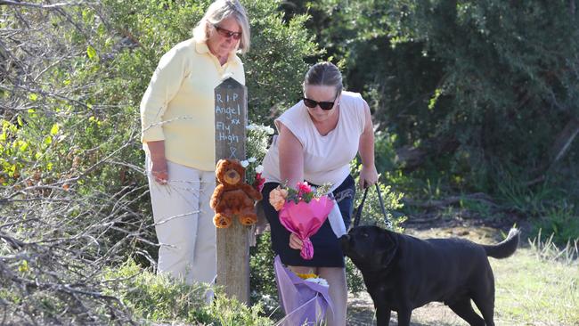 Mourners place flowers at a makeshift shrine where the remains of a newborn girl were found. Picture: David Crosling