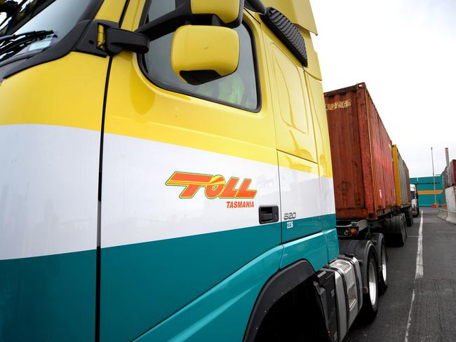 A Toll Holdings truck prepares to offload shipping containers onto a Toll Holdings ship berthed at Webb Dock East in Port Melbourne, Australia, on Wednesday, Aug. 20, 2008. Toll Holdings provides express freight transport by road, rail and sea and provides integrated logistics and distribution systems, including specialized warehousing, port operations, vehicle transport and distribution, and rail passenger operations. The Company also provides coastal shipping, refrigerated freight services, bulk liquid transportation and wharf services. Photographer: Carla Gottgens/Bloomberg News