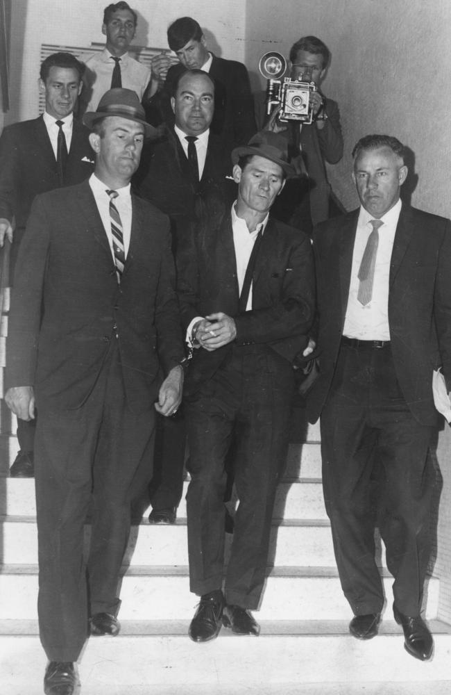 CIB detectives escort Ronald Ryan down the stairs of the old Sydney CIB after his capture by a posse of 50 police.