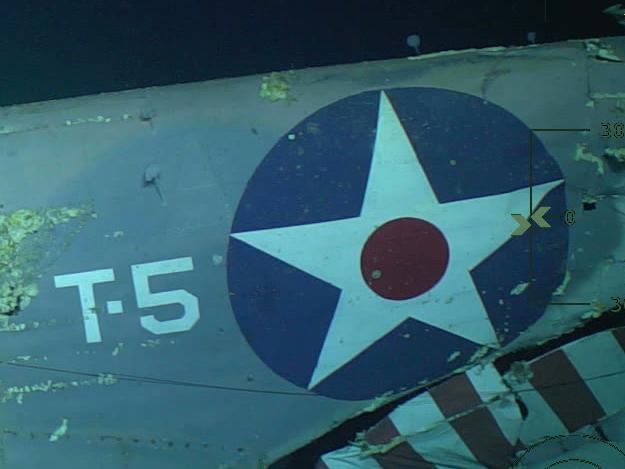 The remains of a US aircraft, its bold blue, white and red markings still clearly evident, sids on the ocean floor ner the aircraft carrier's wreck. Picture: Vulcan