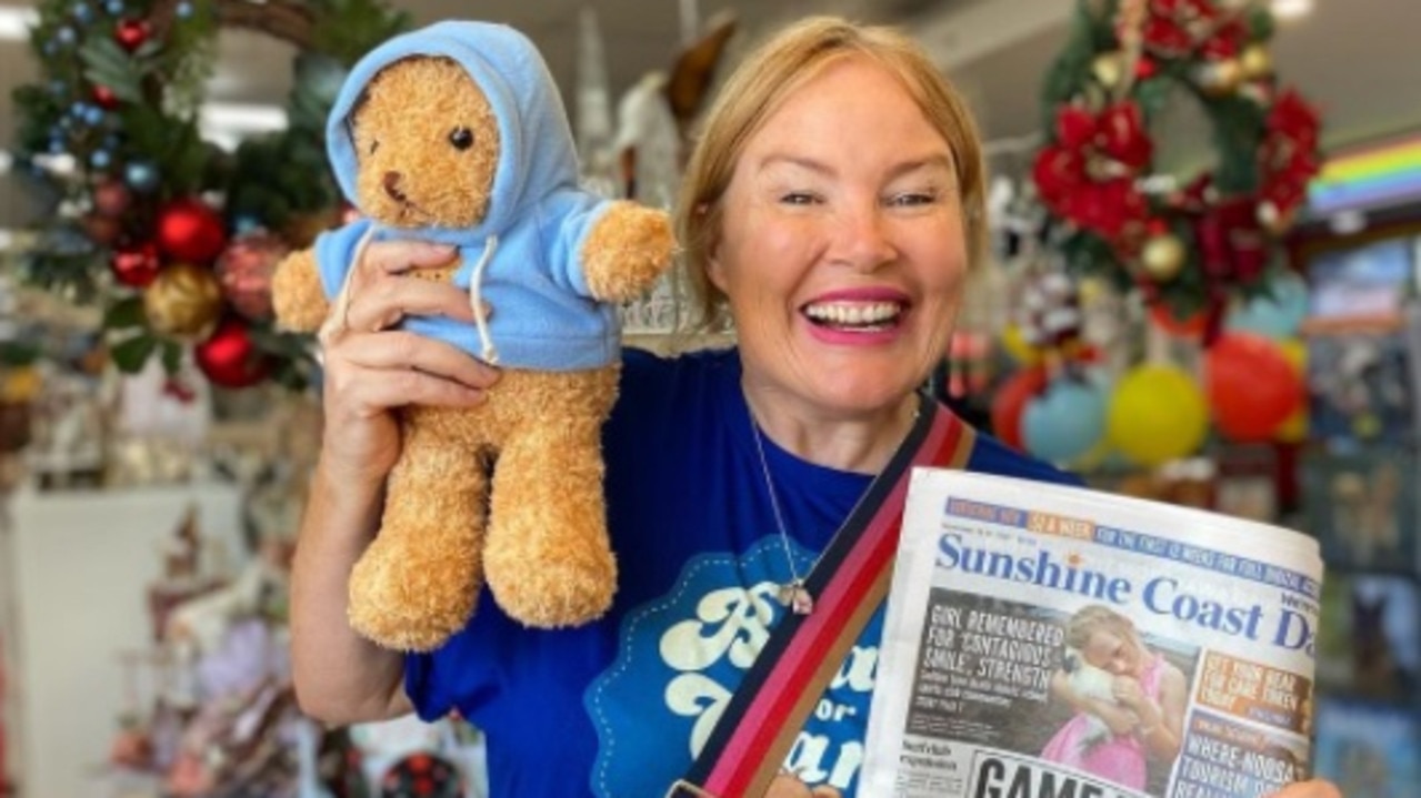 Caroline Hutchinson from 97.2 Mix FM grabs her Bear for Care teddy with her copy of the Sunshine Coast Daily.