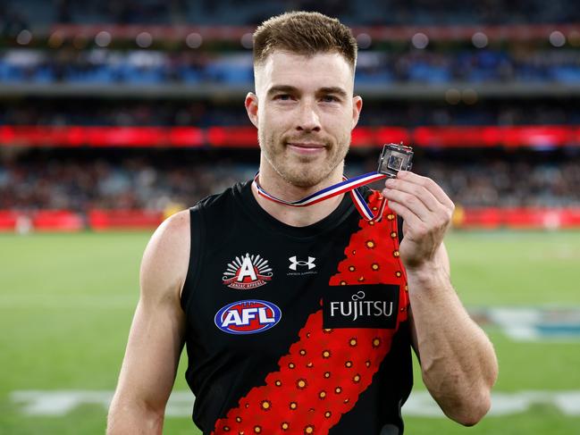 MELBOURNE, AUSTRALIA - APRIL 25: Zach Merrett of the Bombers poses with the Anzac Medal during the 2024 AFL Round 07 match between the Essendon Bombers and the Collingwood Magpies at the Melbourne Cricket Ground on April 25, 2024 in Melbourne, Australia. (Photo by Michael Willson/AFL Photos via Getty Images)