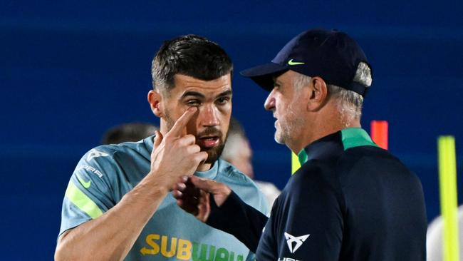 Australia's goalkeeper Mathew Ryan (L) speaks with Australia's coach Graham Arnold.