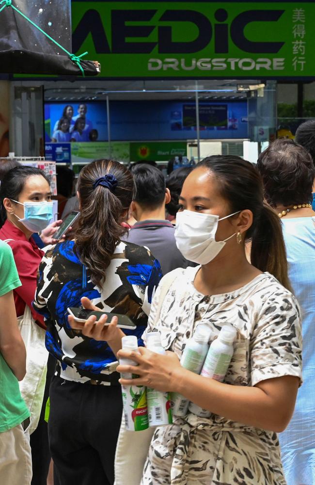 People queue outside a pharmacy to purchase protective face masks, thermometer and hand sanitiser, which has so far confirmed seven cases of the coronavirus. Picture: AFP