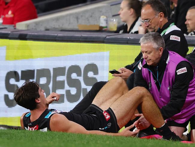 ADELAIDE, AUSTRALIA - APRIL 26: Connor Rozee of the Power on the sidelines in he hands of  trainers during the 2024 AFL Round 07 match between the Port Adelaide Power and the St Kilda Saints at Adelaide Oval on April 26, 2024 in Adelaide, Australia. (Photo by Sarah Reed/AFL Photos via Getty Images)