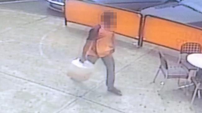 A man was captured on CCTV walking down the street with a petrol container.