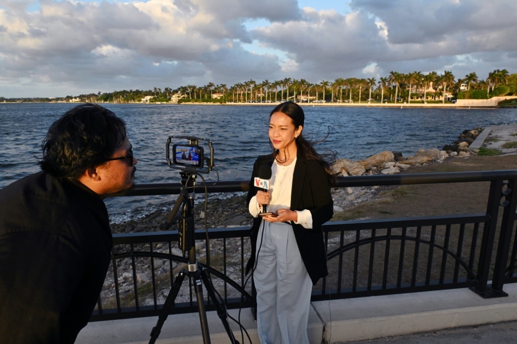 A crew from Voice of America make a live report near Donald Trump's Mar-a-Lago estate in Florida on December 13, 2024