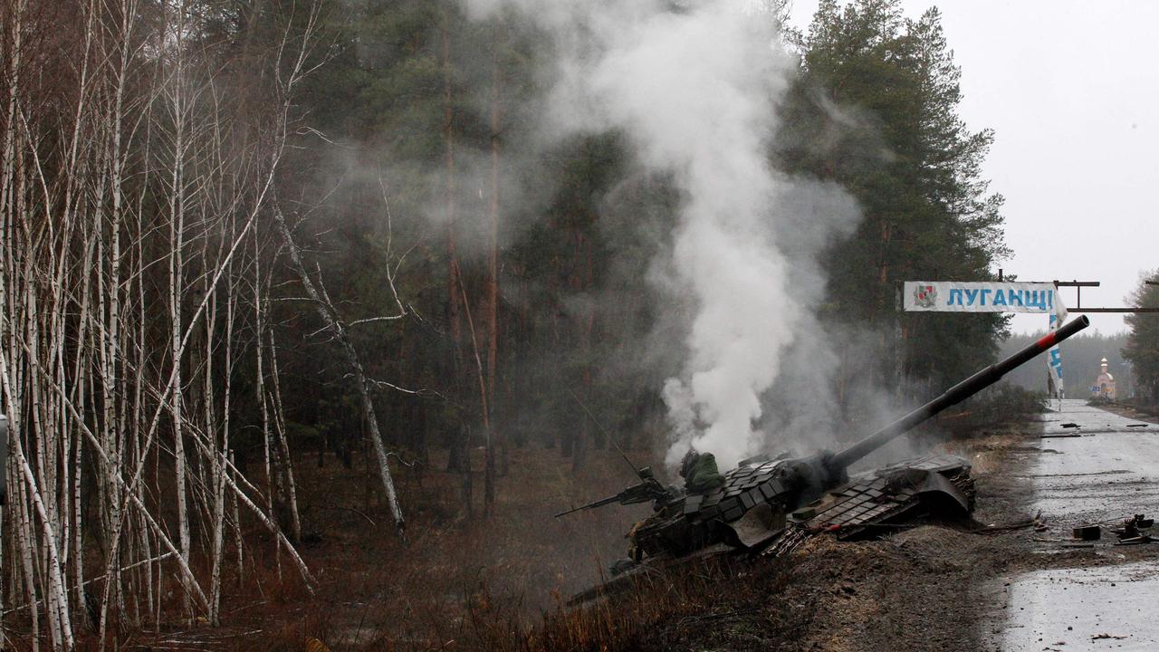 Smoke rises from a Russian tank destroyed by Ukrainian forces on the side of a road in the Lugansk region. Picture: AFP