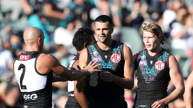 ADELAIDE, AUSTRALIA - APRIL 22: Ryan Burton of the Power celebrates a goal with Sam Powell-Pepper and team mates during the 2023 AFL Round 06 match between the Port Adelaide Power and the West Coast Eagles at Adelaide Oval on April 22, 2023 in Adelaide, Australia. (Photo by Sarah Reed/AFL Photos via Getty Images)