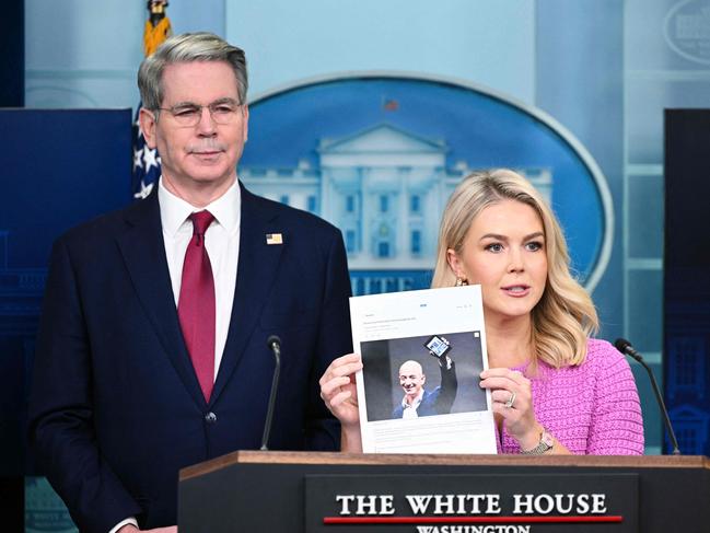White House Press Secretary Karoline Leavitt joined by US Secretary of Treasury Scott Bessent, holds a news article on Amazon CEO Jeff Bezos that reads 