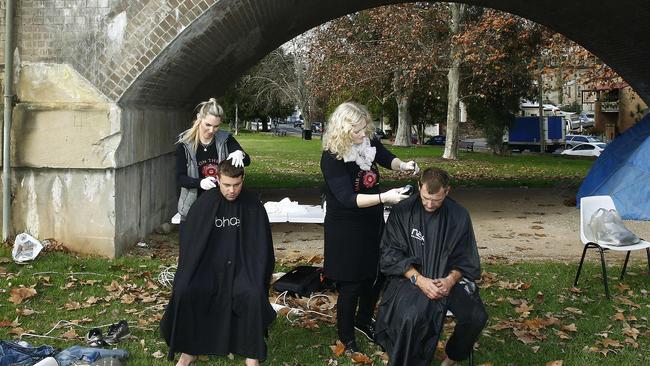 Lyndle Dryan and Beth Shannon from hair on the move cut hair for "Gary " and Dylan McDonald at Wentworth Park. Picture: John Appleyard